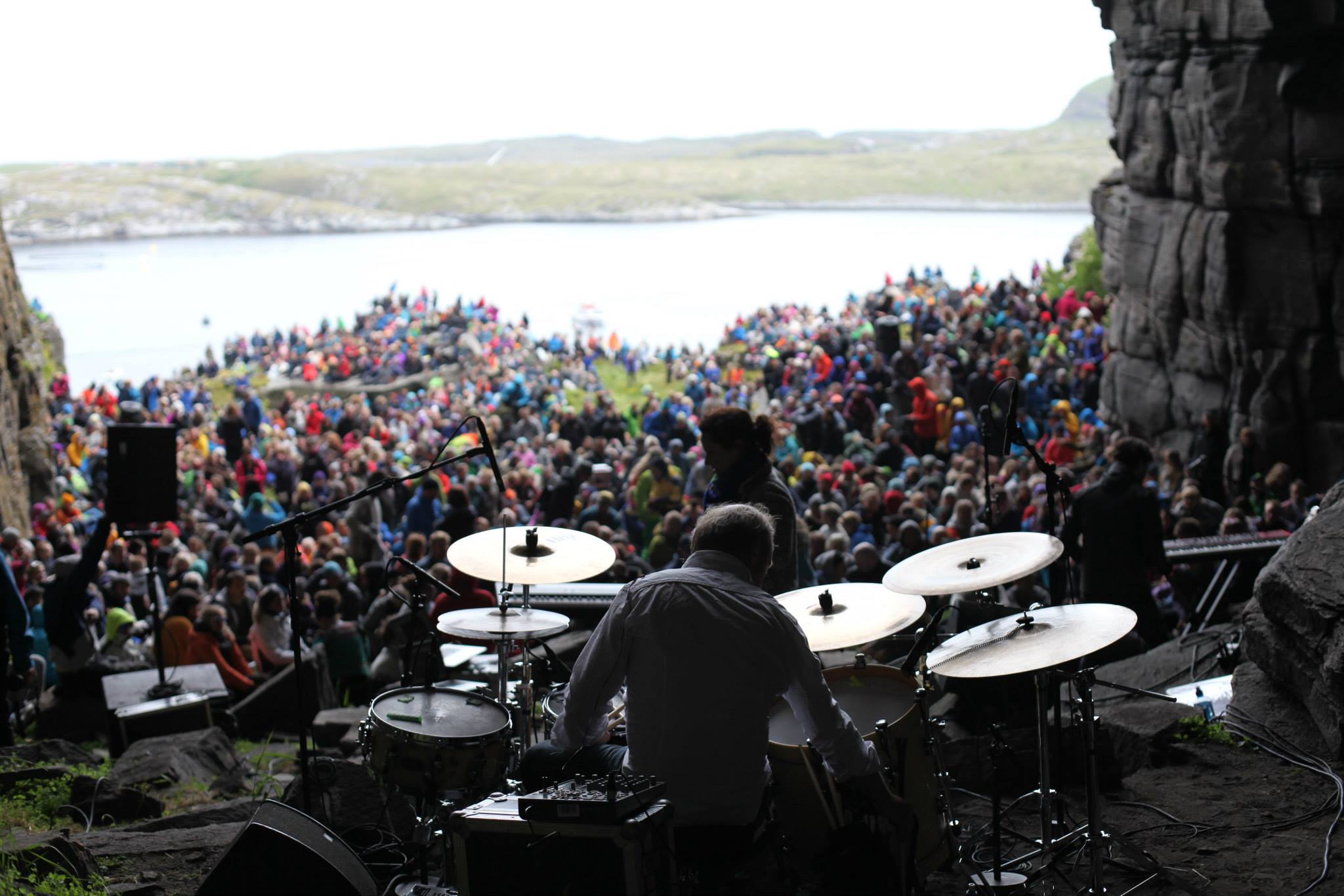 Concert in Kirkhelleren. A drummer and a large audience gathered outside the cave.